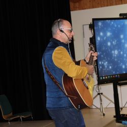 Ein Erwachsener spielt etwas auf einer Gitarre