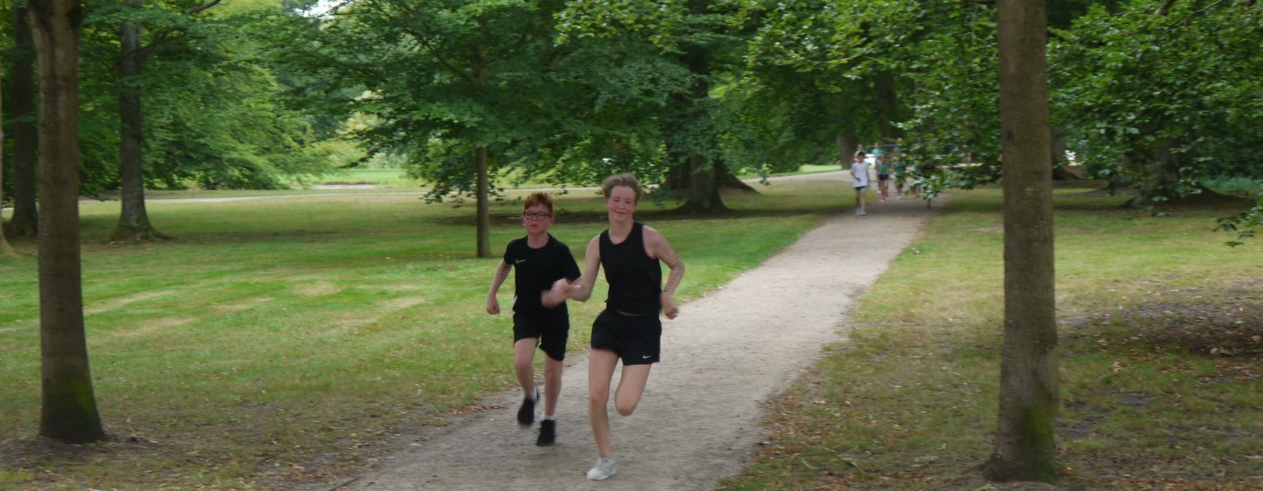 Zwei Jungs die an dem Spendenlauf teilnehmen laufen direkt auf die Kamera zu