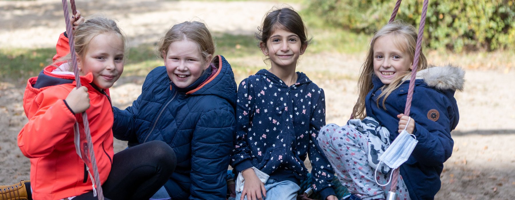 4 Kinder Sitzen auf einer Großen Schaukel